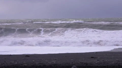 Waves crash on Reynisfjara Beach on a cloudy day Video stock 329442671