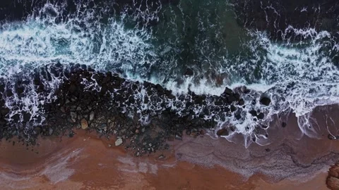 Waves crash on rocks at a beach during daylight Stock Footage 331295645