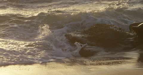 Waves crash onto rocks on beach Stock Footage 68560001