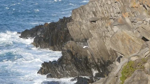 Waves crash into rocky coast Video stock 107990650