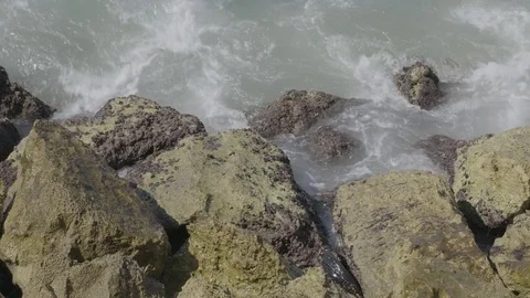 Waves crash up on rough rocks background Stock Footage 82833142