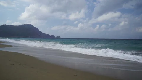 Waves crash on the sandy beach and cloudy sky above the sea. Stock Footage 273919607