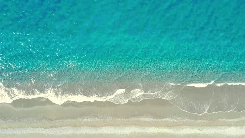 Waves Crash on Sandy Beach During Sunny Day by the Ocean With Clear Blue Water Stock Footage 322937725
