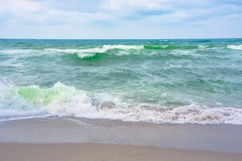 Waves crash on sandy beach Stock Photos