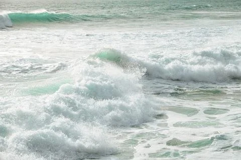 Waves crash on sandy beach, sunset with an empty shoreline and gentle breeze Stock Photos
