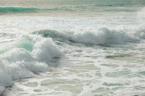Waves crash on sandy beach, sunset with an empty shoreline and gentle breeze Stock Photos