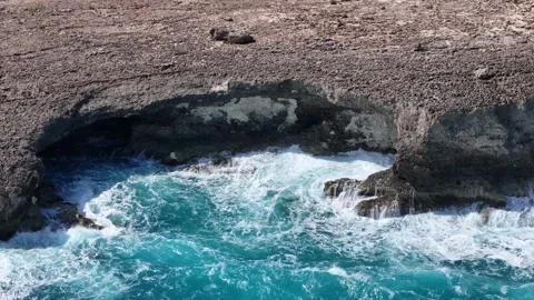 Waves crash sea cave arch limestone cliff base malta whitewater surf explodes Video stock 343595934