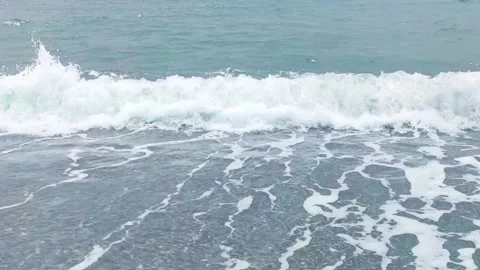 Waves Crash on the Shore at a Beach During Midday Under a Clear Sky Stock Footage 330795482