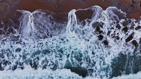 Waves crash onto the shore at a beach in the early morning light 库存影片 331296095