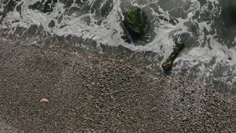 Waves crash in slow motion over rocky shore Stock Footage 169098495