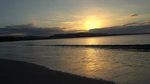 Waves crash on a tropical beach at sunset Stock Footage 105872730