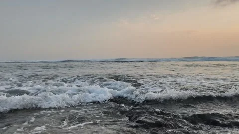 Waves crashed against the dark, wet rocks as the sun set. Stock Footage 341662044