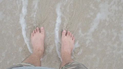 The waves crashed at the feet of a lonely man standing, top view slow motion Stock Footage 129349903