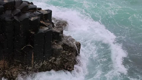 Waves crashing against basalt columns at coastal cliff during ocean storm. Stock-Footage 333885734