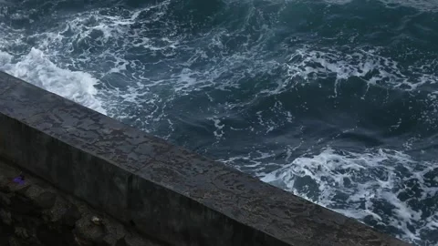 Waves crashing against the beach wall Stock Footage 252628477