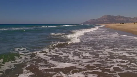 Waves crashing against an empty sand beach Stock Footage 162046622