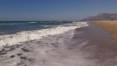 Waves crashing against an empty sand beach Video stock 162046653