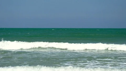 Waves crashing against a flat sandy beach in slow motion Stock Footage 76337249
