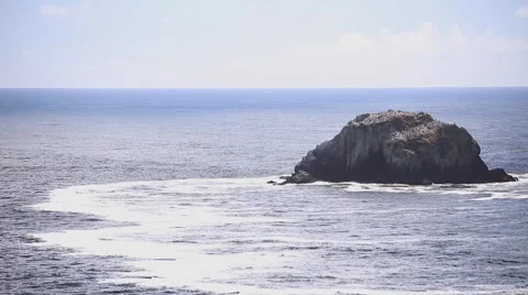Waves Crashing against a Hollow Sea Stack Stock Footage 62581753