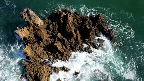 Waves crashing against jagged rocks in green sea in Cascais, Portugal Stock Footage 219327614