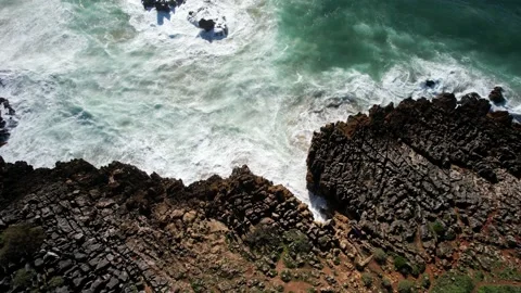 Waves crashing against jagged rocks in green sea in Cascais, Portugal Stock Footage 224905799