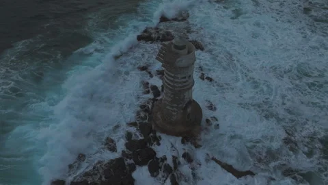 Waves crashing against Mangiabarche Lighthouse in Sardinia at sunset Stock Footage 313291418