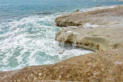Waves crashing against rocks on a rugged coastline in Cyprus. Scenic rocky sh Fotos de archivo