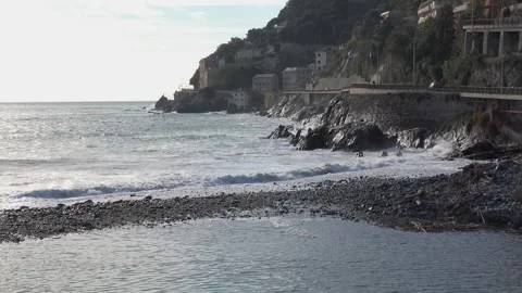 Waves crashing against the rocky cliffs of the coast on a sunny day, along t Stock Footage 293360211