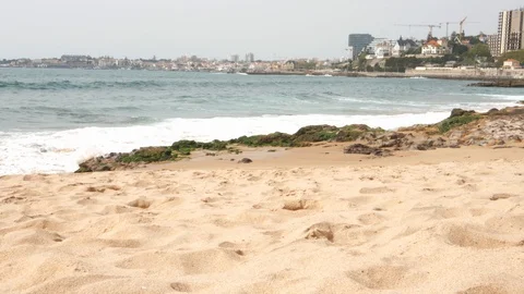Waves crashing on a beach by the Atlantic Ocean in Cascais, Portugal with cute Stock Footage 126650027