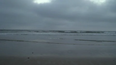 Waves crashing on beach on cloudy day Stock Footage 125804211