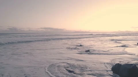 Waves crashing on beach during sunset 動画素材 201839136