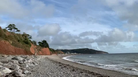 Waves crashing on a beach with orange cliffs. Stock-Footage 219890773