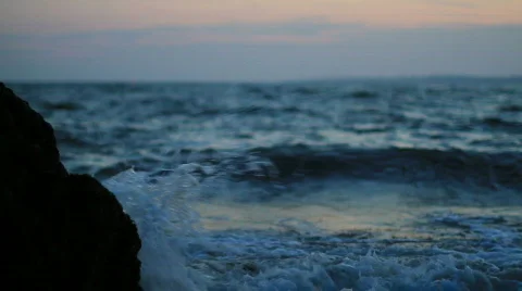 Waves crashing onto the beach with red sky Stock-Footage 864092