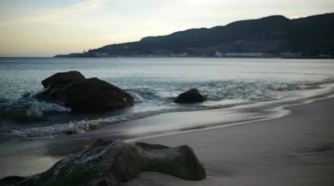 Waves crashing on beach at sunset Stock Footage 41805159