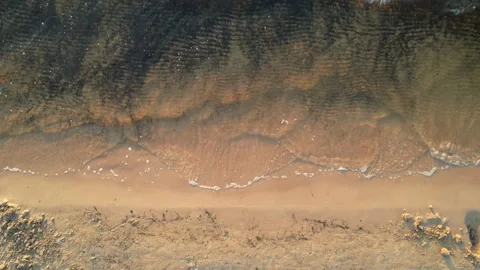 Waves crashing on beach while camera flying up Stock Footage 276945524
