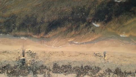 Waves crashing on beach while camera flying up Stock Footage 276945806