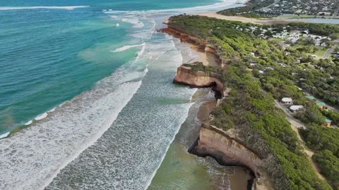 Waves crashing below sea cliffs and an eroded coastline Stock Footage 325276547