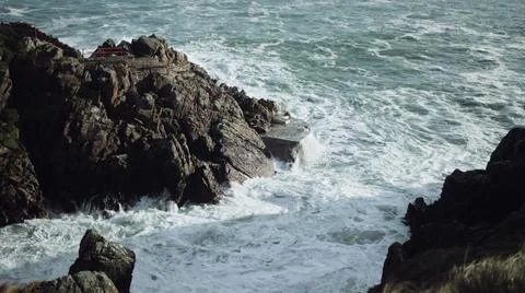 Waves crashing between the cliffs of Fanad Head Lighthouse. coast of County D Stock Photos