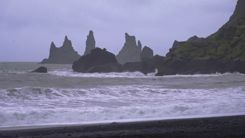 Waves crashing on black sand beach in Vik, Iceland on moody, overcast day 스톡 동영상 327082495