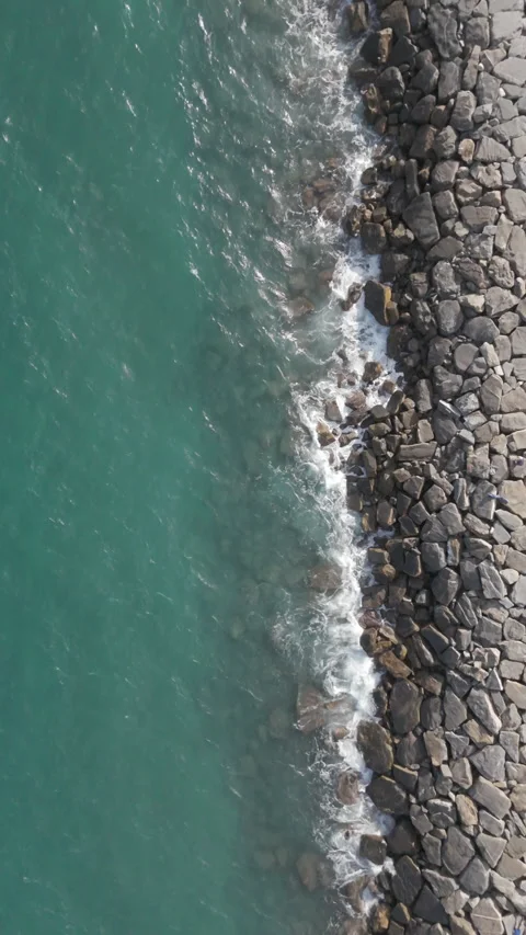 Waves crashing into breakwater Stock Footage 303066674