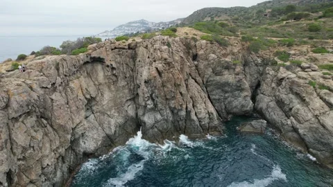 Waves crashing on cliff drone flight in Punta Falconera Stock Footage 294204106