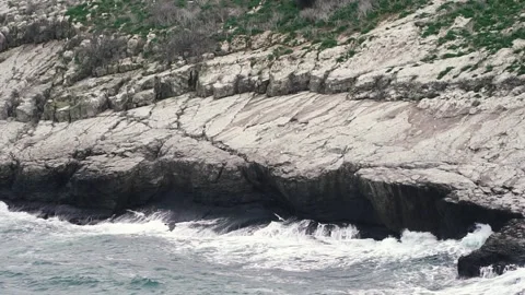 Waves crashing onto cliffs slowmotion Video stock 144976957