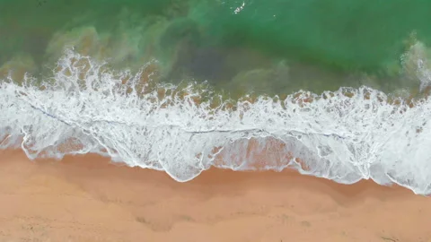 Waves crashing gently on an ocean beach Stock Footage