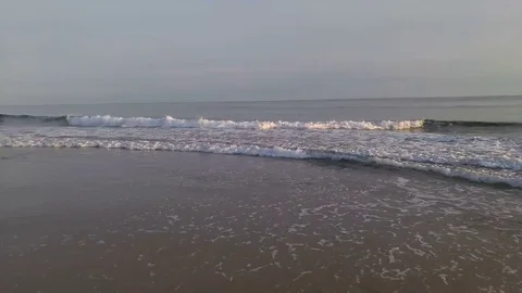 Waves crashing gently on a quiet sandy beach. Sunset time Vídeos de archivo 74938715