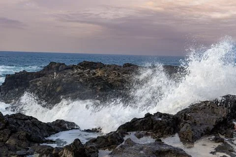 Wave's Crashing into a large rock in Maui, Hawaii Stock Photos