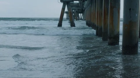 Waves crashing next to a pier 2 Stock Footage 106629542