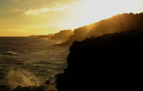 Waves crashing on ocean cliffs at sunset Stock Photos
