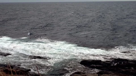 Waves crashing onto ocean rocks 動画素材 332890133
