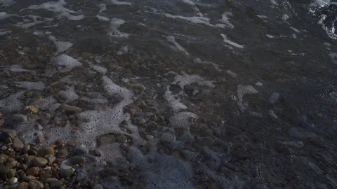 Waves crashing over beach pebbles and stones Stock Footage 122736344