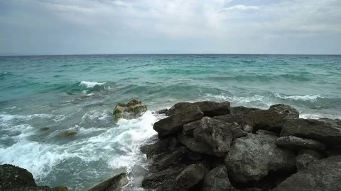 Waves crashing over the big rocks on a cloudy day Stock Footage 82212247